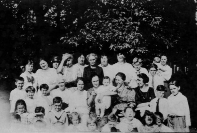 Looks like Dorothy front and Centre, Birley second row on right 2nd from end, Wes and Bert 3rd row on right in front of woman holding baby